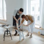 A couple actively engaged in a creative project within a well-lit art studio, fostering collaboration.